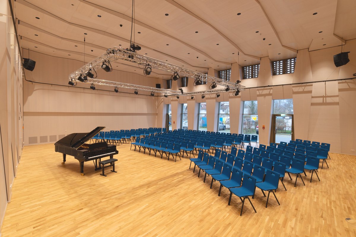 Konzertsaal mit Flügel und blauen Stuhlreihen in der BB-Musikakademie Staufen