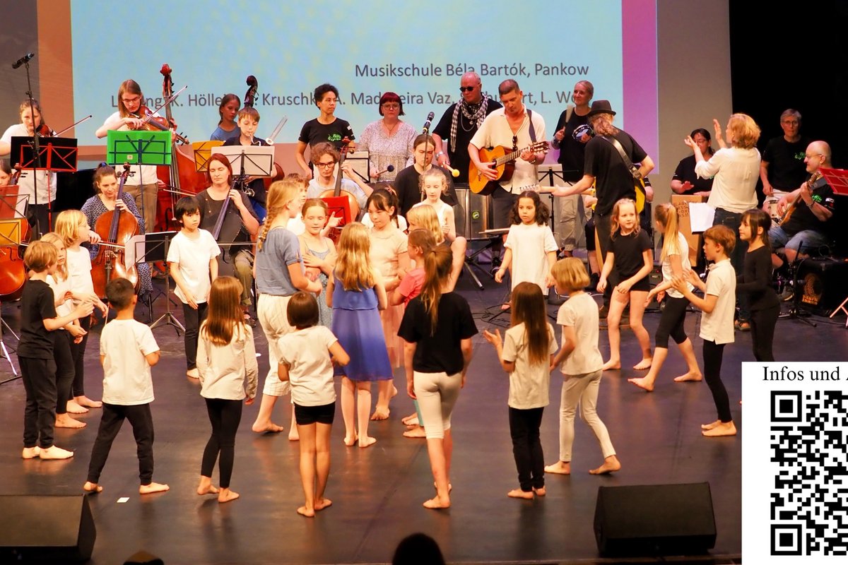 Kinder tanzen und ein Orchester spielt
