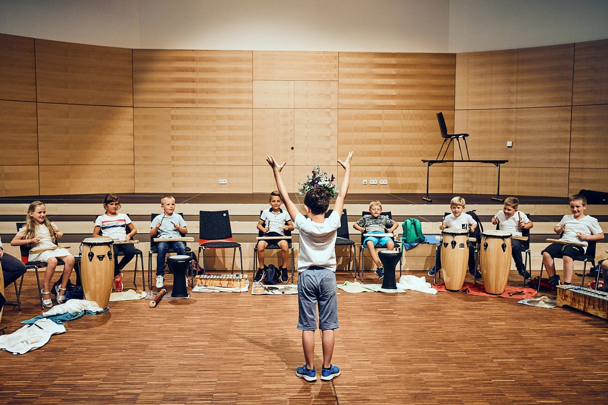 Kind dirigiert Kinder vor Instrumenten